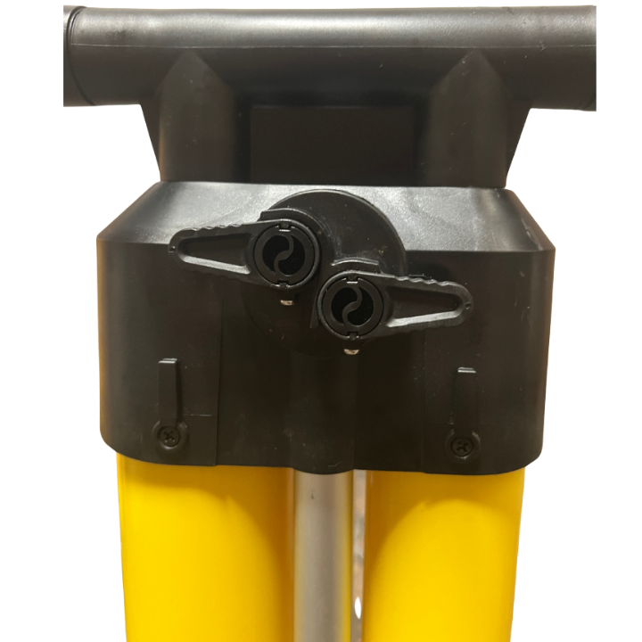 Close-up of a pump's connection area showing two black hose connectors with silver metal valves, attached to bright yellow cylindrical pump cylinders and a black handle.